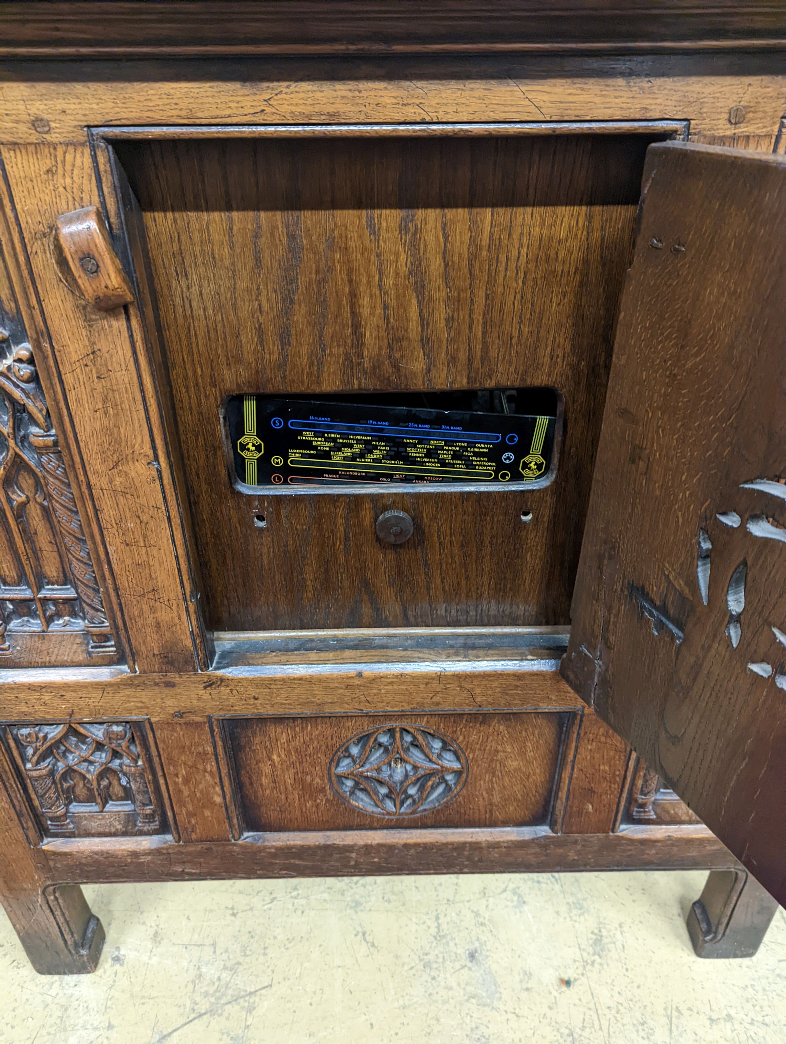 A Garrard Radiogram in a Gothic revival carved oak case. W-98cm,D-49cm, H-101cm.